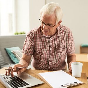 Man with laptop, paper and mug
