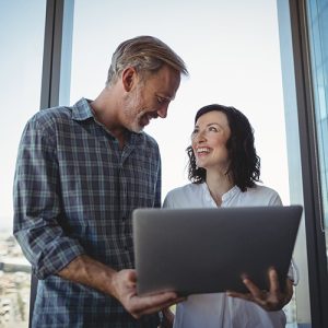 Man and woman having discussion over laptop