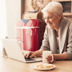 Woman reading news on a laptop with breakfast