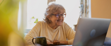Woman using computer with mug of coffee