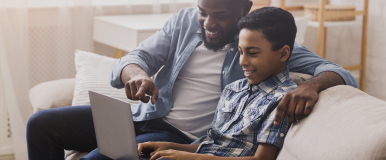 Adult male and boy using computer together