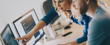 Co-workers looking at computer screen together